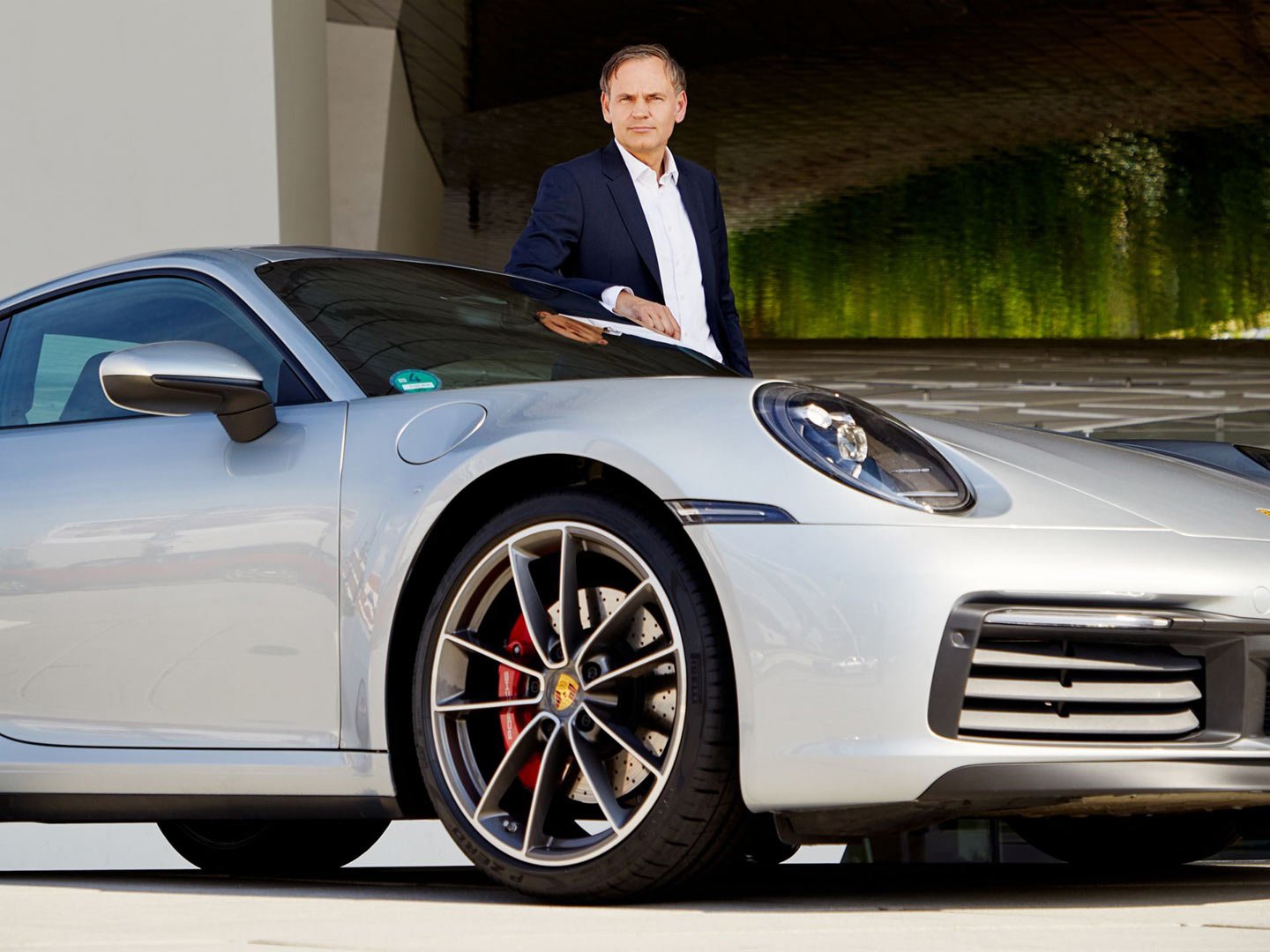 Porsche CEO Oliver Blume Standing by Porsche 911